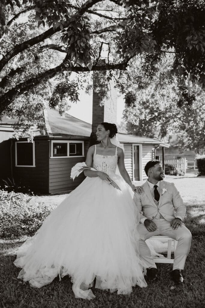 Bride and groom laughing together under a tree at their rustic farm wedding